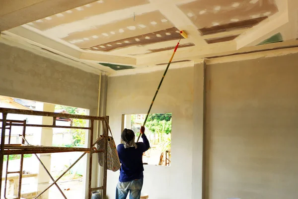 stock image Painters are painting the ceiling of a new home.
