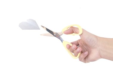 Beyaz arka planda izole edilmiş kağıt kalbi kesmek için bir makas tutuyor..