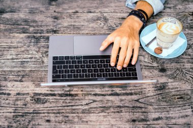 Kısmi açık kafe içinde laptop ile genç adam görünümünü