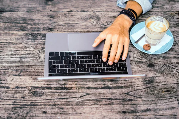Kısmi açık kafe içinde laptop ile genç adam görünümünü