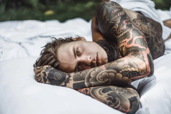 Guapo Joven Tatuado Hombre Relajarse Cama Blanca —  Fotos de Stock