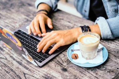 Kısmi açık kafe içinde laptop ile genç adam görünümünü