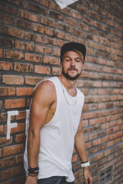 Bir havuzda pateni bir şık genç adam bir skatepark, bir kaykay üzerinde beyaz bir T-shirt ve şapka paten.