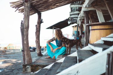 Uzun sarı saçlı ve köpekle oynamayı dövmeler yakışıklı yetişkin adam