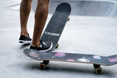 Bir havuzda pateni bir şık genç adam bir skatepark, bir kaykay üzerinde beyaz bir T-shirt ve şapka paten.