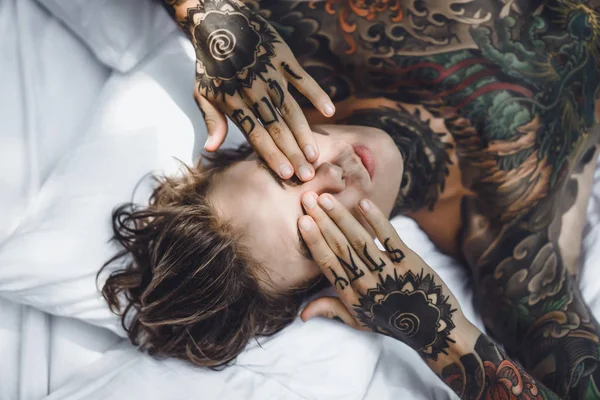 Beau Jeune Homme Tatoué Relaxant Sur Lit Blanc — Photo