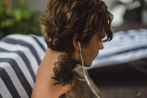 Молодой Человек Татуировках Наушниках Слушает Музыку Рисует Карандаш Блокноте Онлайн — стоковое фото