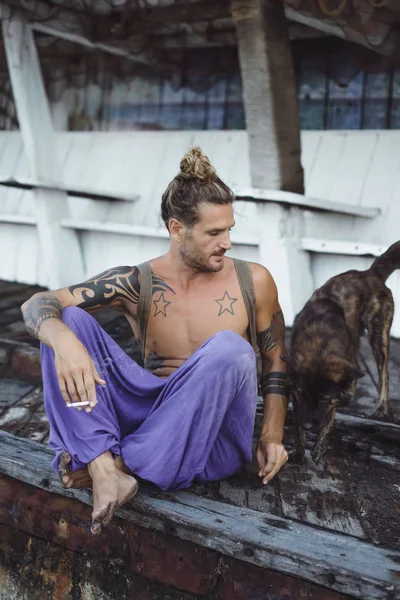 Uzun Sarı Saçlı Köpekle Oynamayı Dövmeler Yakışıklı Yetişkin Adam — Stok fotoğraf