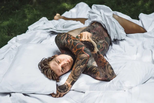 Beau Jeune Homme Tatoué Relaxant Sur Lit Blanc — Photo