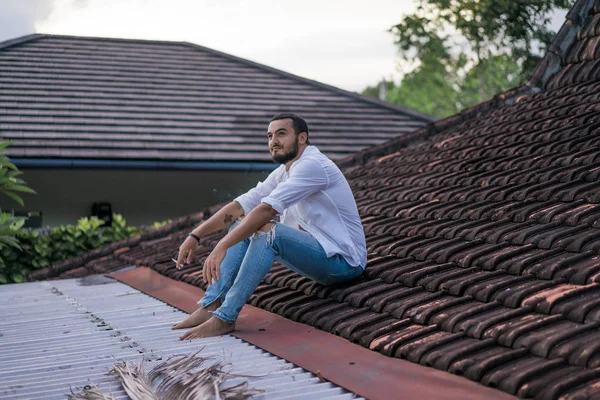 Genç Yakışıklı Adam Çatıda Sigara Içiyor — Stok fotoğraf