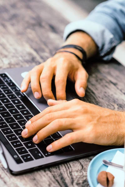 Kısmi açık kafe içinde laptop ile genç adam görünümünü