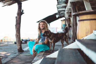 Uzun sarı saçlı ve köpekle oynamayı dövmeler yakışıklı yetişkin adam