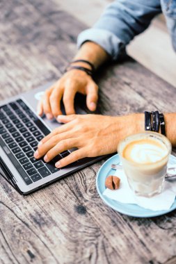 Kısmi açık kafe içinde laptop ile genç adam görünümünü