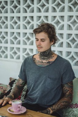 dövmeli adam bir kafede kahve içme