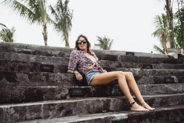 renkli bir gömlek ve belgili tanımlık merdiven üstünde poz güneş gözlüğü giyen güzel kız kot şort uzun bacaklı