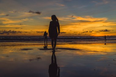 Kız batan güneşin fonunda atlıyor.