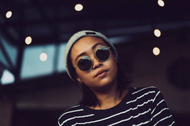 Endonezya kız hippi gri bir şapka ve güneş gözlüğü. Dövme güzel şık Asyalı kadın.