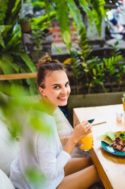 Şık bir kafe, sağlıklı kahvaltı, meyve, taze sıkılmış meyve suyu, kahvaltı güzel bir kadın olan tropikal konumu.