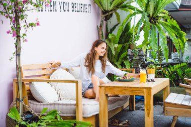 Şık bir kafe, sağlıklı kahvaltı, meyve, taze sıkılmış meyve suyu, kahvaltı güzel bir kadın olan tropikal konumu.