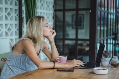 kız bir kafede çalışıyor. kavramı freelancing, kahve ve dizüstü.