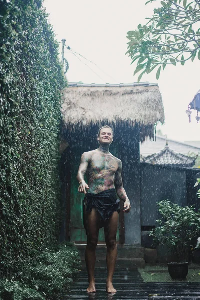 年轻的纹身男子在雨中摆姿势 — 图库照片