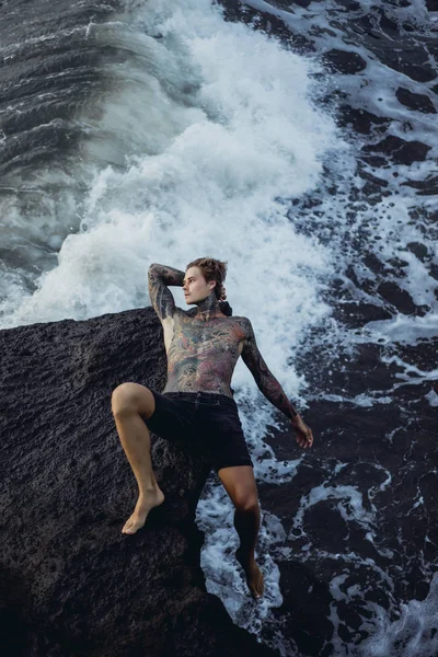 悬崖边上的纹身男子 海浪飞溅 — 图库照片