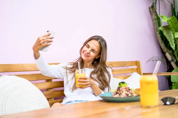 Beautiful Woman Cafe Makes Selfie Smartphone Drinks Freshly Squeezed Juice — Stock Photo, Image