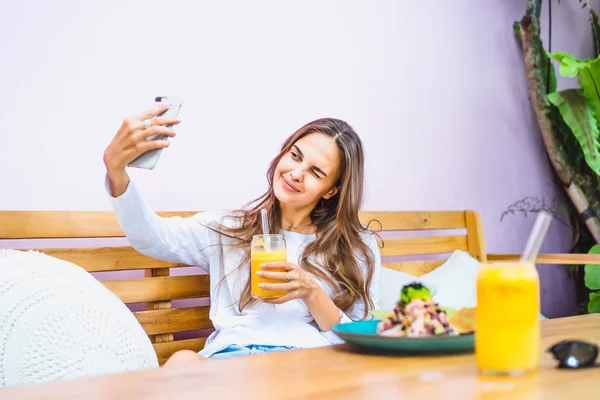 Beautiful Woman Cafe Makes Selfie Smartphone Drinks Freshly Squeezed Juice — Stock Photo, Image