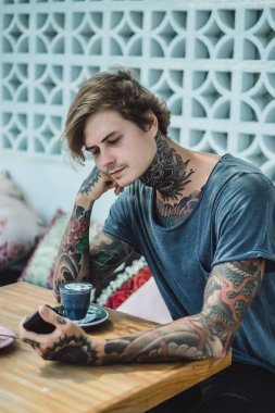 kahve, siyah ve pembe renkli kapuçino. dövmeli bir adam renkli bir kahve bir kafede içecekler..