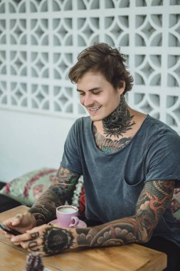 dövmeli adam bir kafede kahve içme