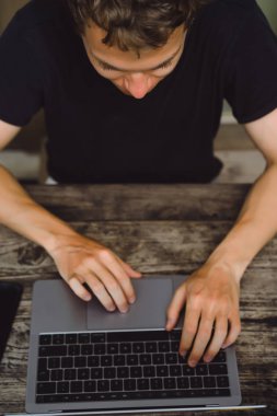 ahşap bir masa, çalışan bir bilgisayar, smartphone, dizüstü bilgisayar, masaüstü üzerinde bir erkeğin elinde üstünde Laptop.