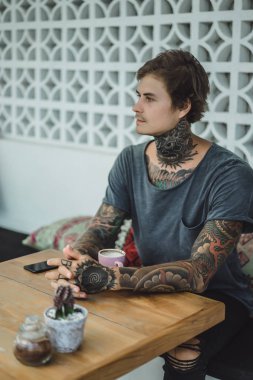 dövmeli adam bir kafede kahve içme