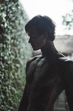 Genç dövmeli adam karşı yağmur poz