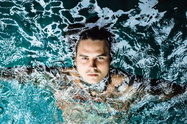 dövmeli adam yağmur havuzunda. yakın çekim, portre, açık havada