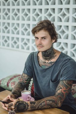 dövmeli adam bir kafede kahve içme