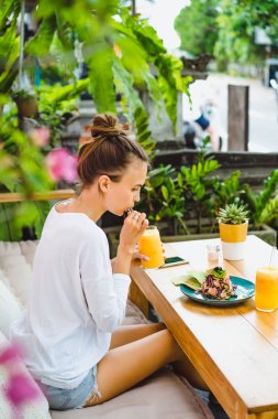 Şık bir kafe, sağlıklı kahvaltı, meyve, taze sıkılmış meyve suyu, kahvaltı güzel bir kadın olan tropikal konumu.