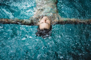 dövmeli adam yağmur havuzunda. yakın çekim, portre, açık havada