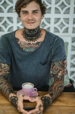 dövmeli adam bir kafede kahve içme