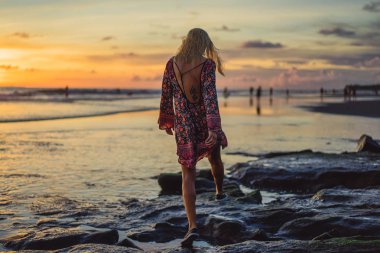 Kız batan güneşin fonunda atlıyor.