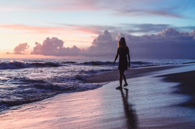 Kız batan güneşin fonunda atlıyor.