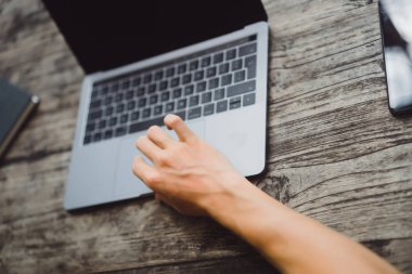 ahşap bir masa, çalışan bir bilgisayar, smartphone, dizüstü bilgisayar, masaüstü üzerinde bir erkeğin elinde üstünde Laptop.