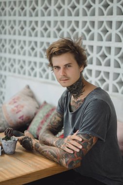 bir sipariş için bekleyen bir smartphone, içecekler kahve, dövmeli bir adam bir kafede kullanır.