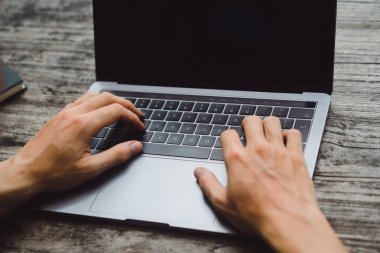 ahşap bir masa, çalışan bir bilgisayar, smartphone, dizüstü bilgisayar, masaüstü üzerinde bir erkeğin elinde üstünde Laptop.