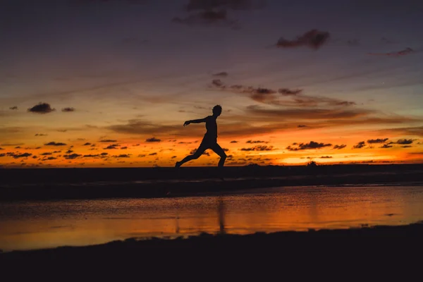 Человек Берегу Океана Закате Человек Прыгает Фоне Заходящего Солнца — стоковое фото