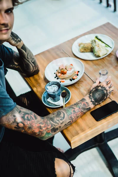 Joven Hombre Tatuado Comiendo Panqueques Manos Smartphone Comida —  Fotos de Stock