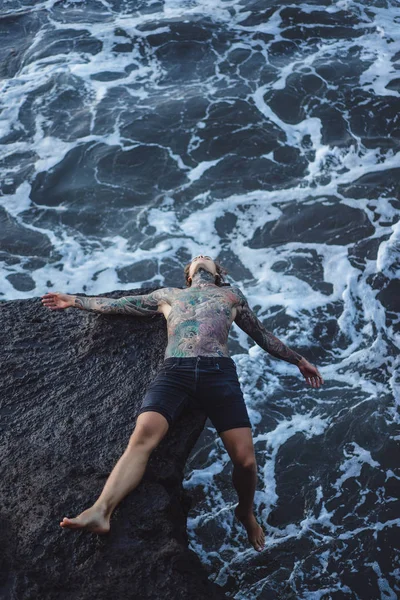 Tattooed Man Edge Cliff Splashes Ocean Waves — Stock Photo, Image