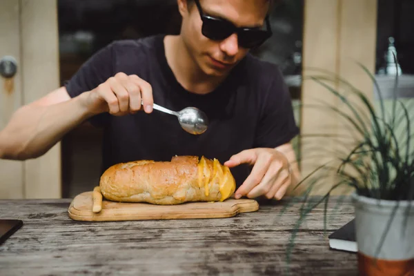 the man in the cafe has soup in a plate of bread.