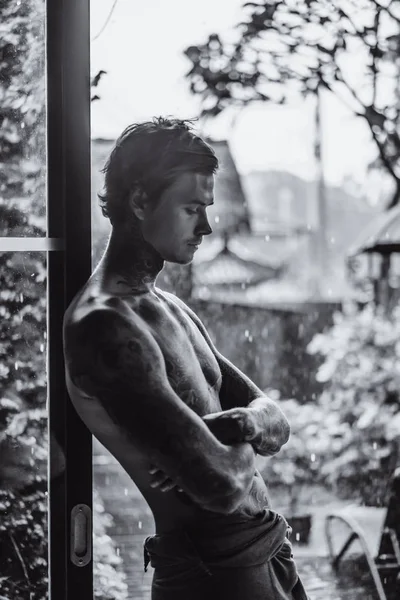 雨に対するポーズ若い刺青男 — ストック写真