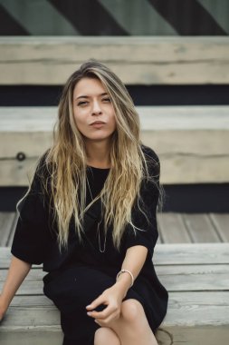 Dışarıda uzun saçlı genç ve güzel bir kadın portre pozu veriyor..