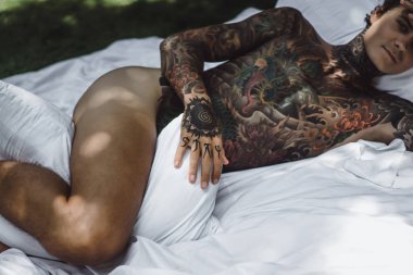 yakışıklı, Genç bir dövmeli adam sabah yatakta yastık fırlatır. Bahçe yatağında